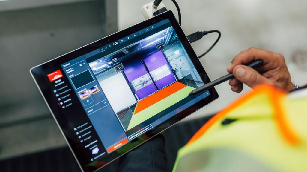 Tablet sa softverom za kontrolu vrata Linde Door Control, kojim operater stilusom podešava zone otvaranja industrijskih vrata.